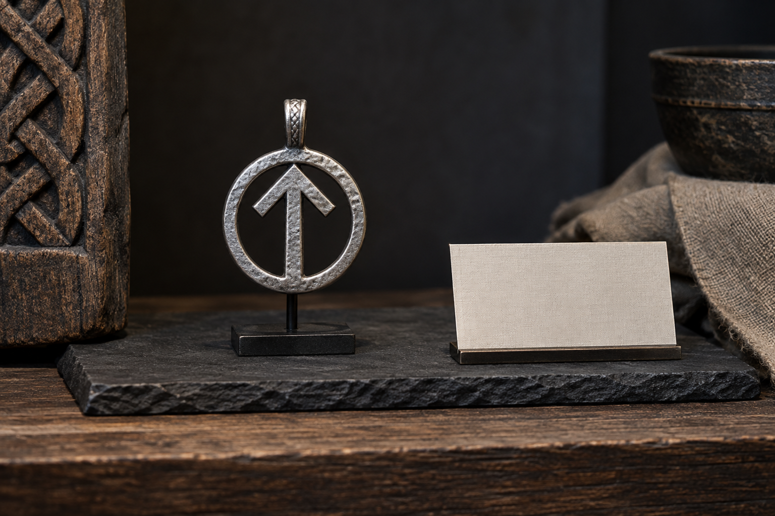 Silver Tiwaz-inspired rune pendant in a neutral museum-style display